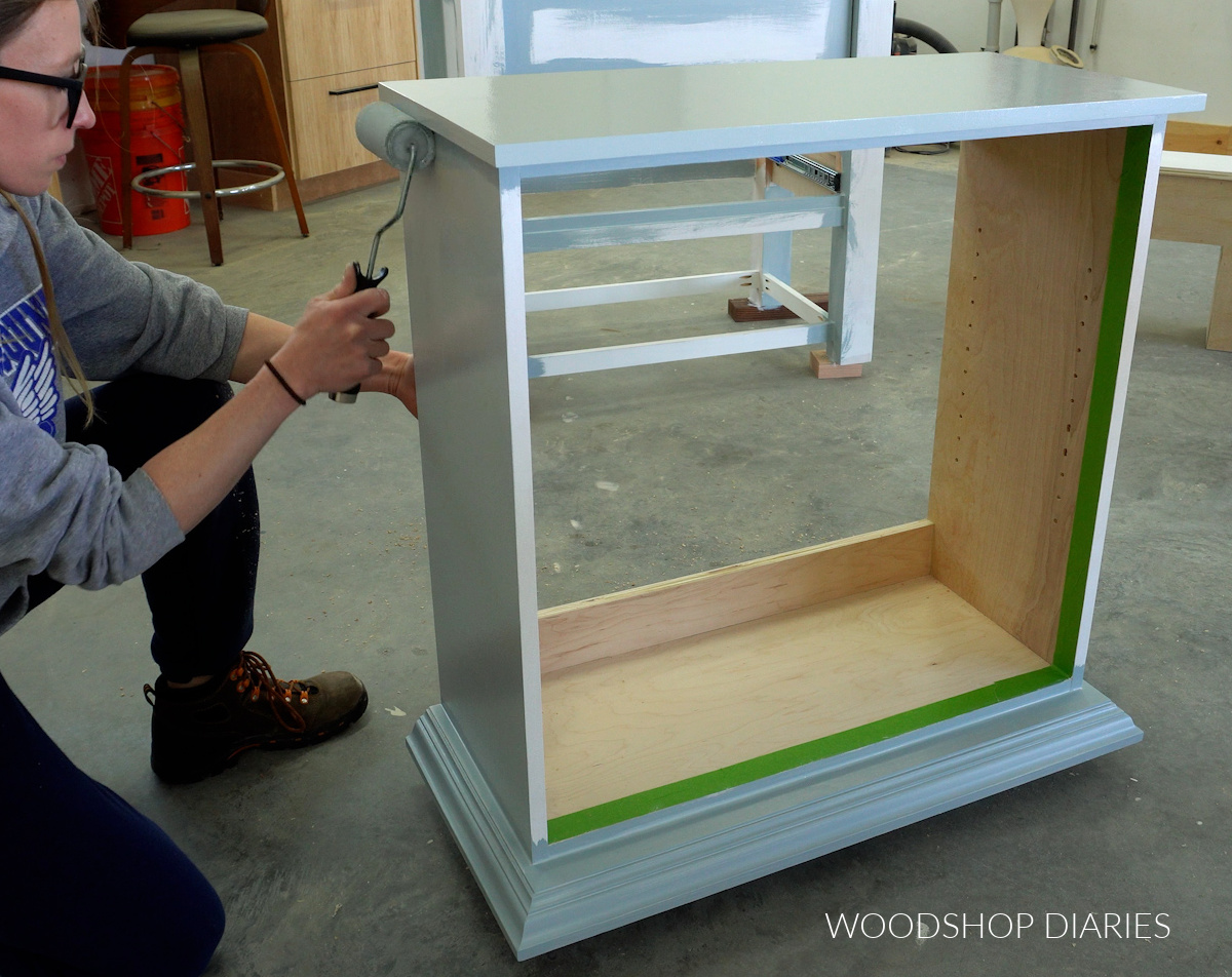 Shara Woodshop Diaries painting cabinet with paint roller