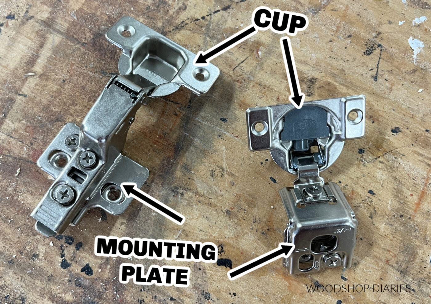 two hinges on workbench with arrows pointing to the cups and mounting plates on each