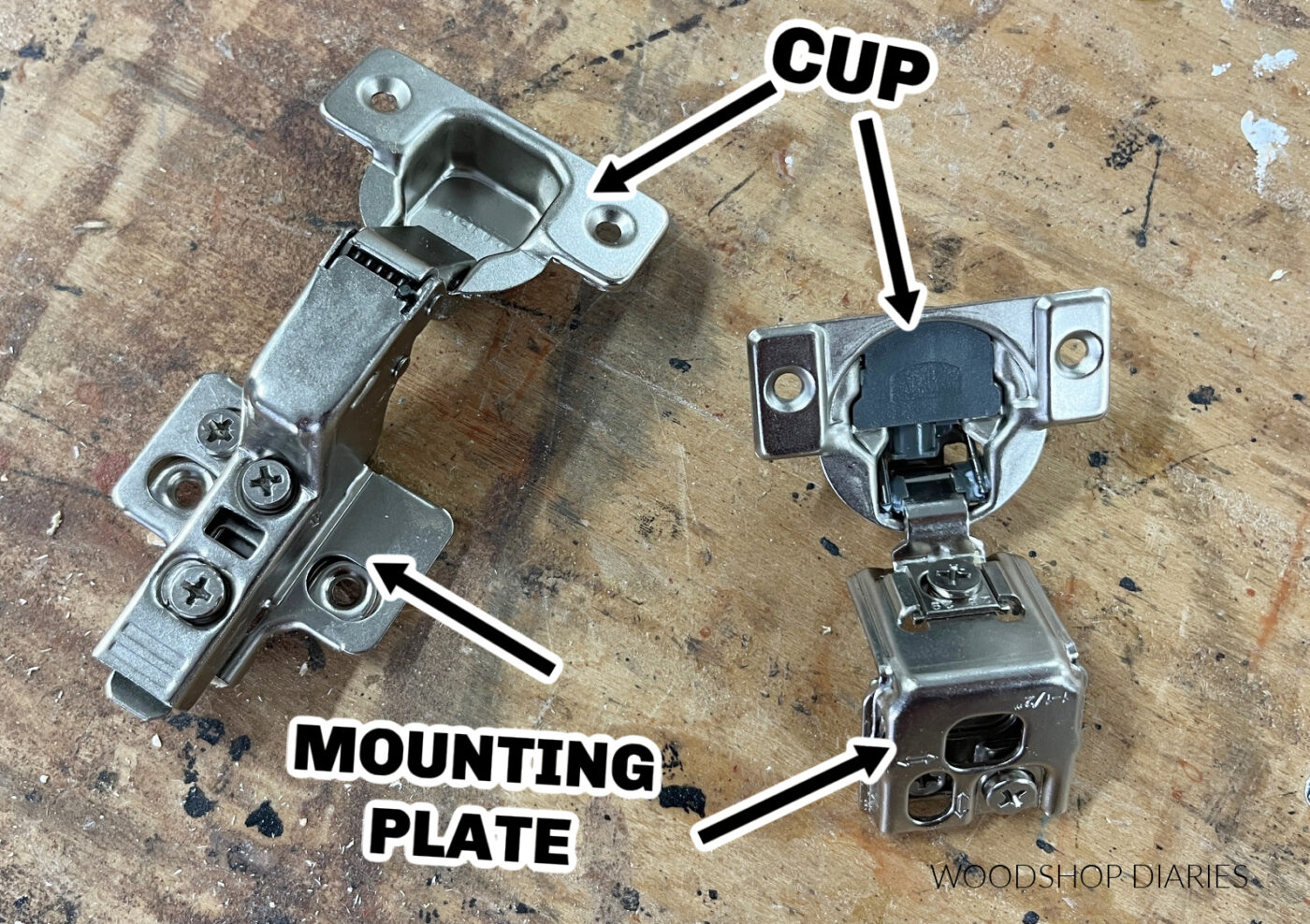 two hinges on workbench with arrows pointing to the cups and mounting plates on each