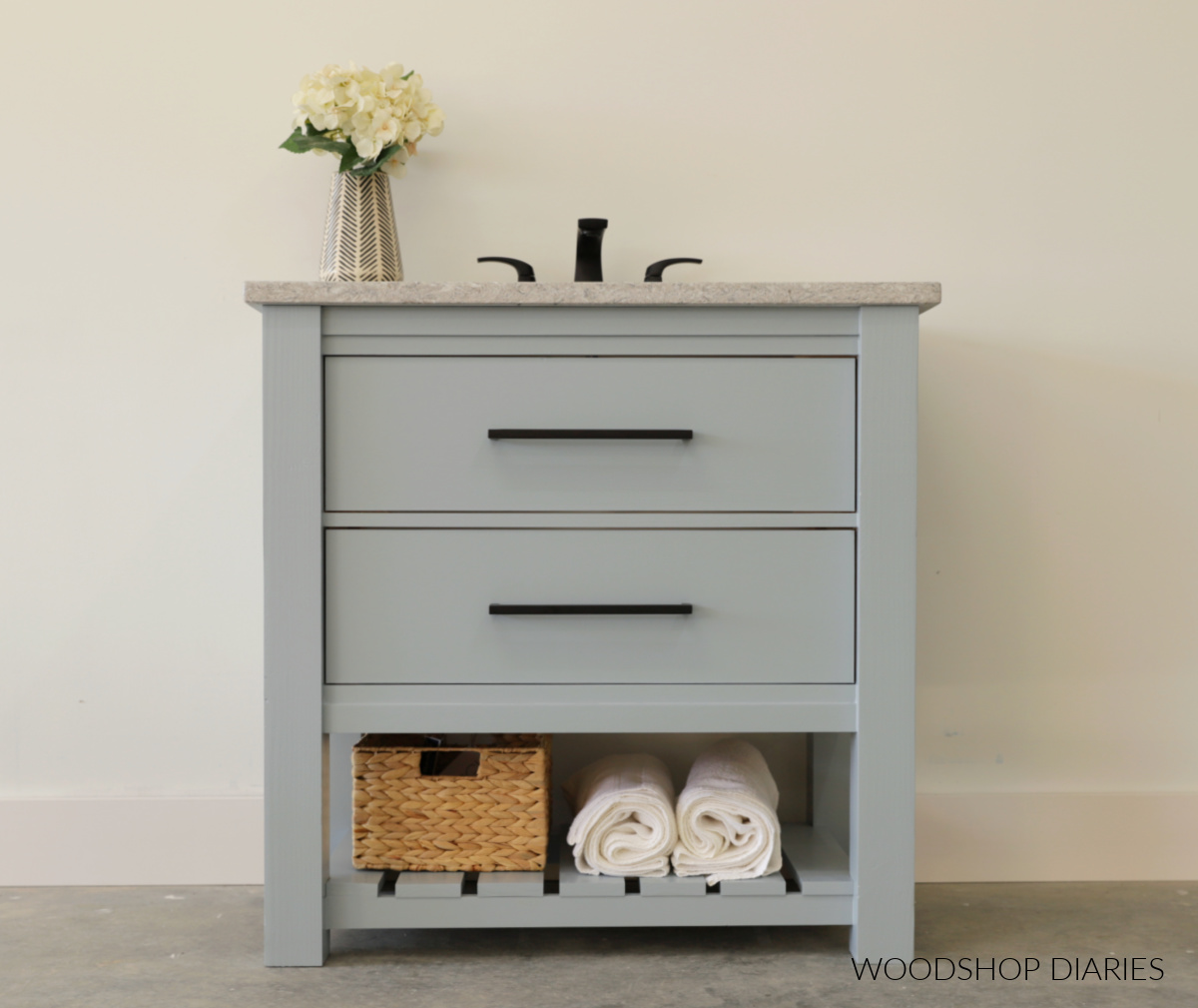 Blue single sink vanity with two large drawers and open shelf with granite top