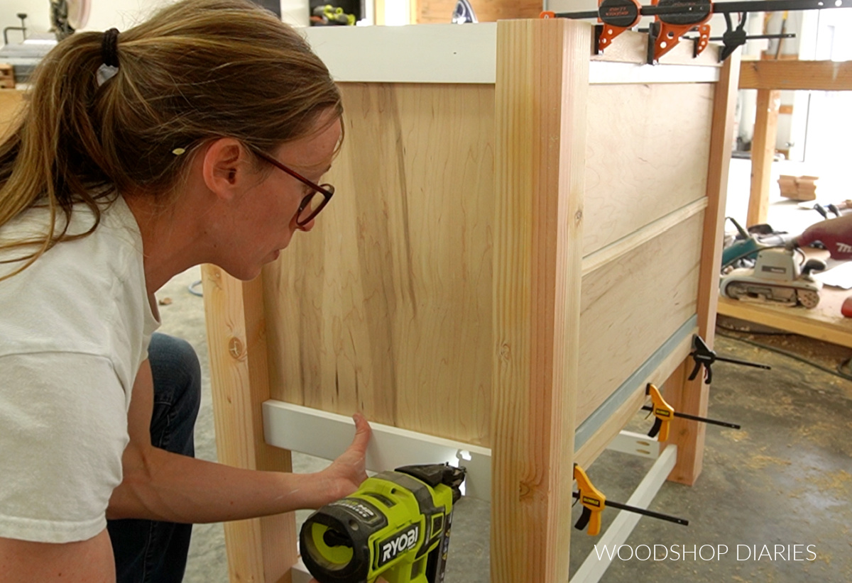 Shara Woodshop Diaries nailing trim onto sides of bathroom vanity