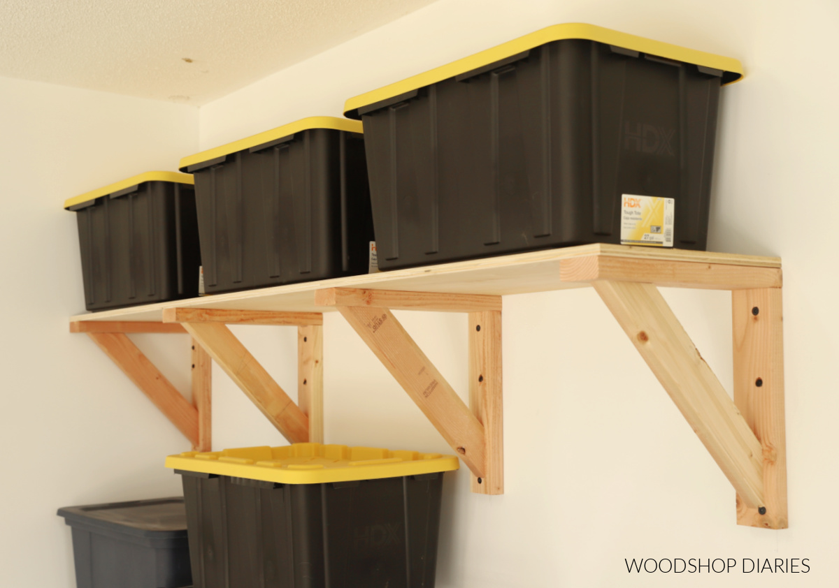 Garage wall shelf with black and yellow storage totes on top