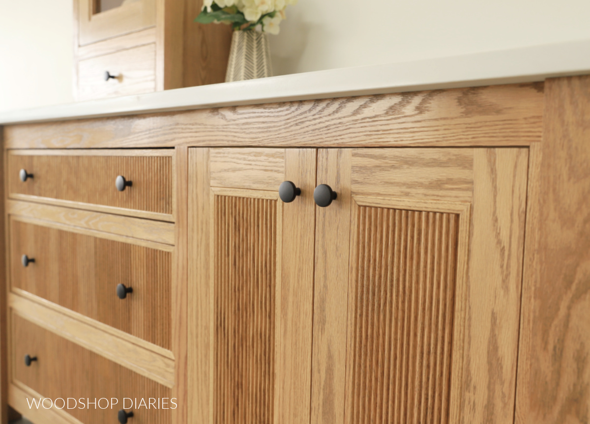 Close up of red oak bathroom vanity fluted wood doors and drawers
