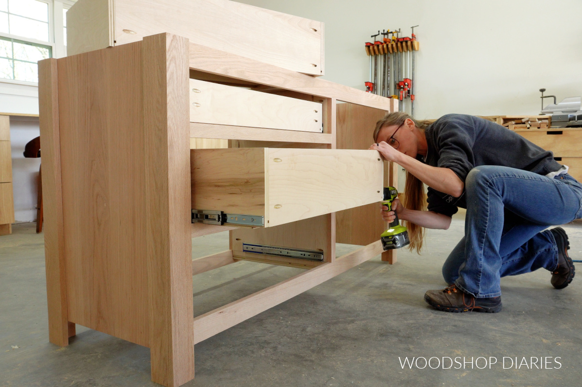 Shara Woodshop Diaries installing drawer boxes onto drawer slides in bathroom vanity in workshop