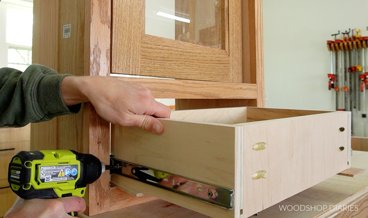 Driving screws to install drawer box onto drawer slides in countertop bathroom cabinet