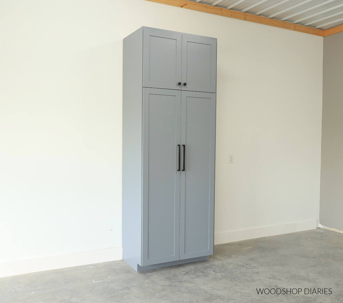 Tall pantry cabinet with four doors against white wall