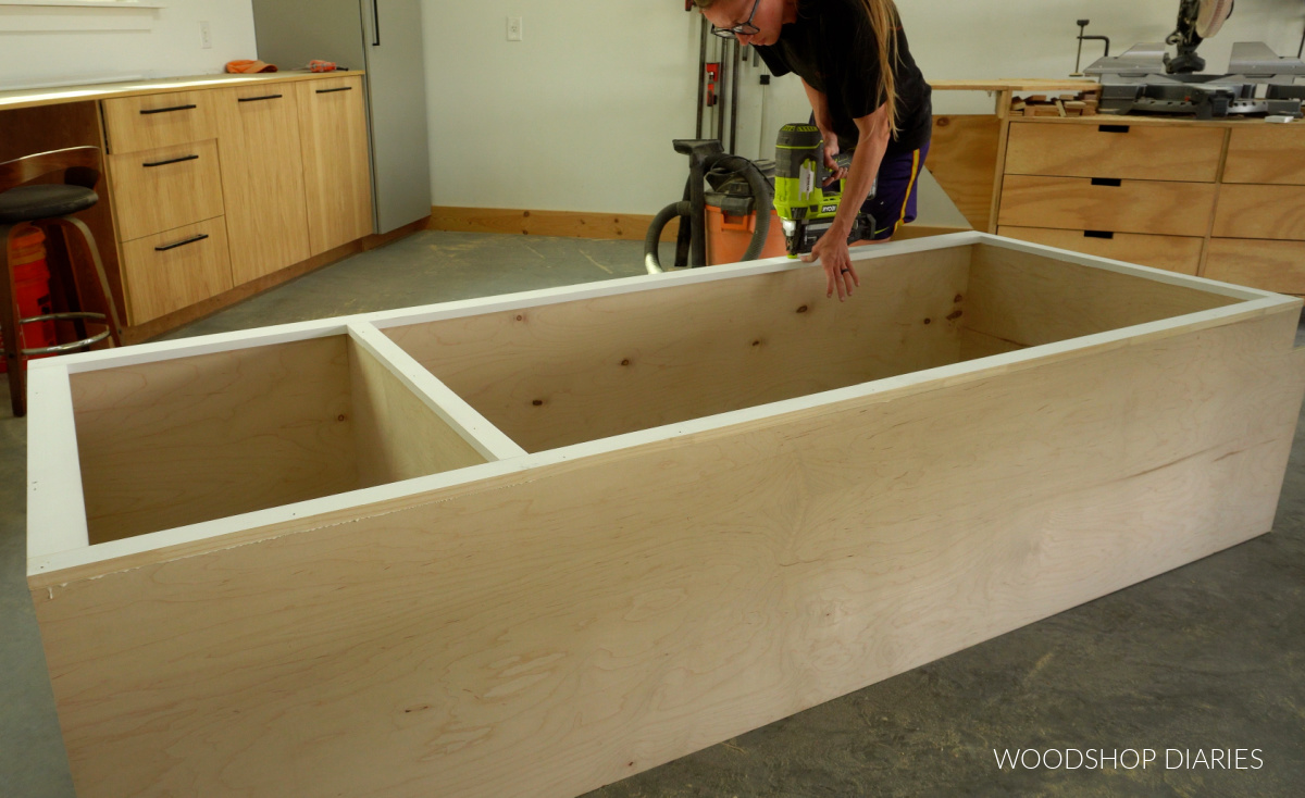 Shara Woodshop Diaries nailing face frame onto front of pantry cabinet