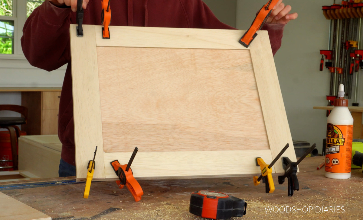 Plywood cabinet door in clamps on workbench