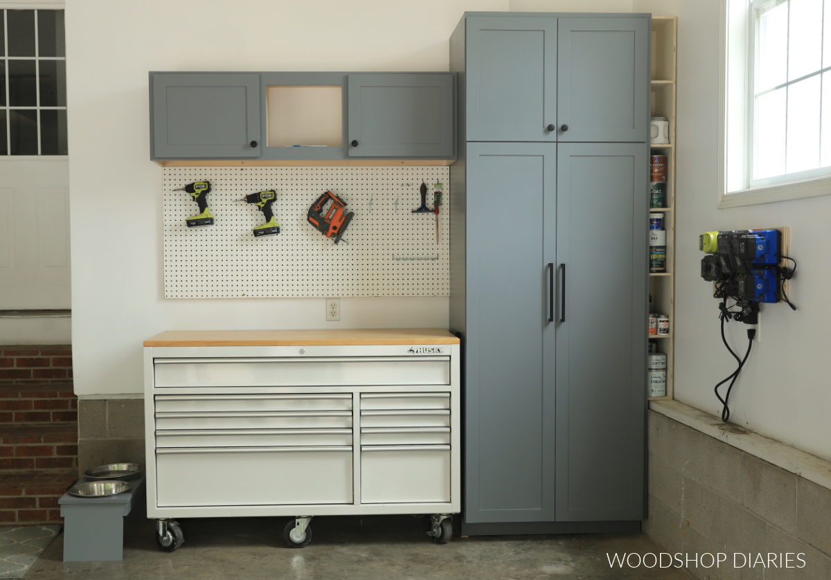 DIY garage makeover complete with tool chest, tall storage cabinet, upper cabinet, peg board, and battery charging station