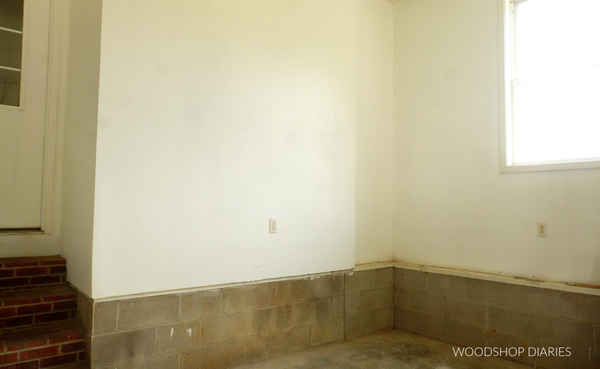 Empty garage wall with concrete blocks and white painted drywall