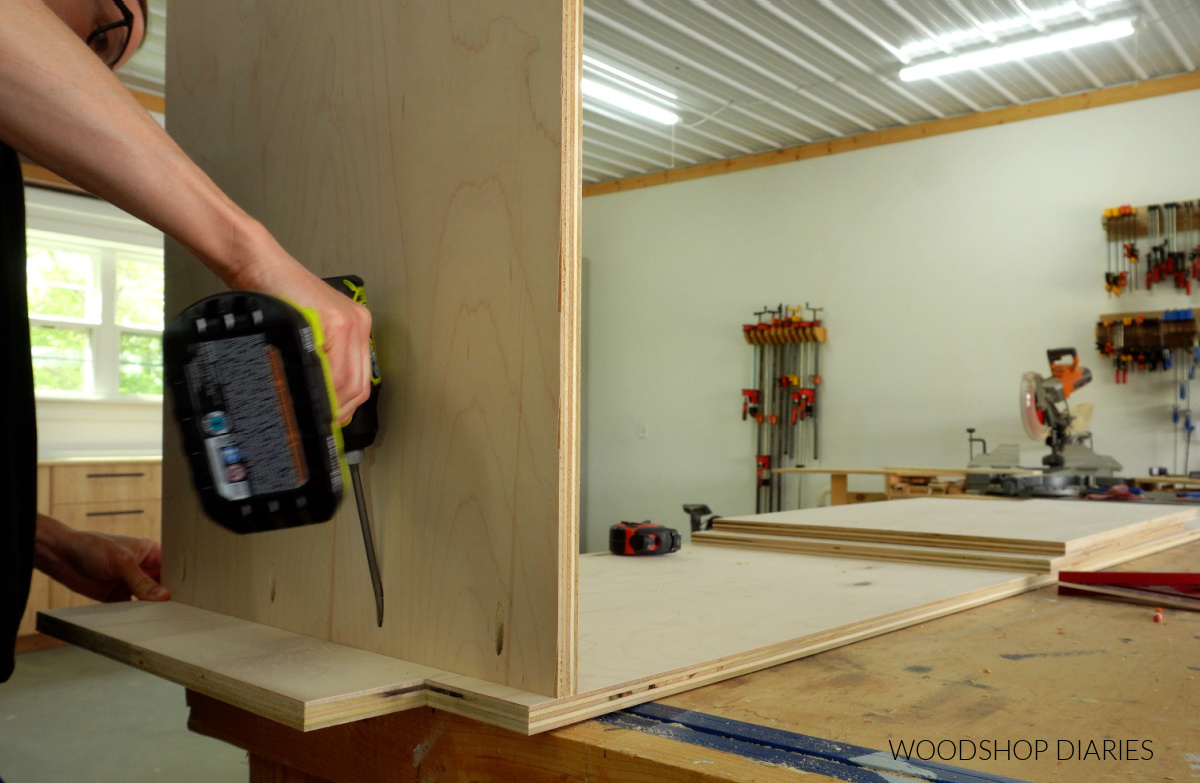 Shara Woodshop Diaries installing the bottom panel of pantry cabinet with pocket holes and screws