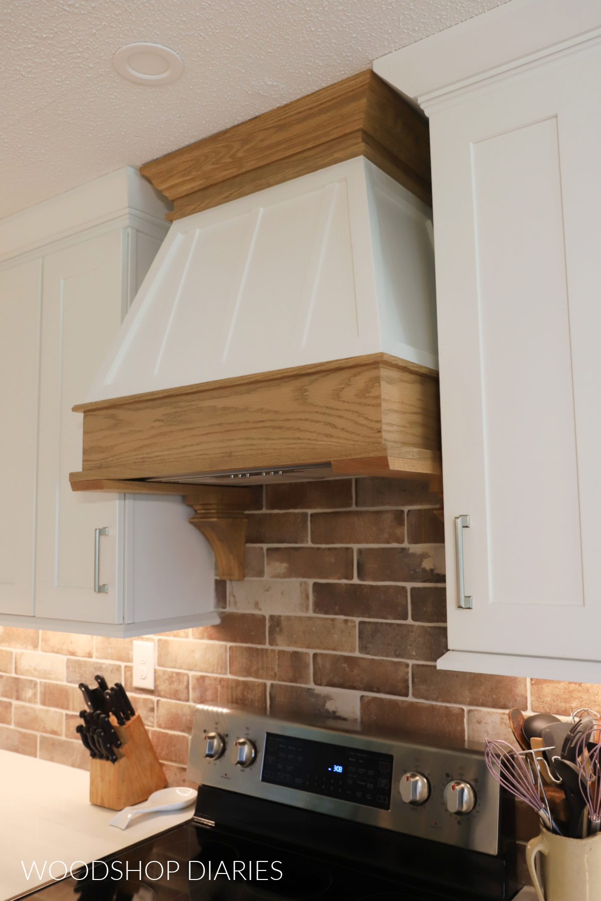 Completed two tone wooden range hood cover with wood stained top and bottom and painted middle section