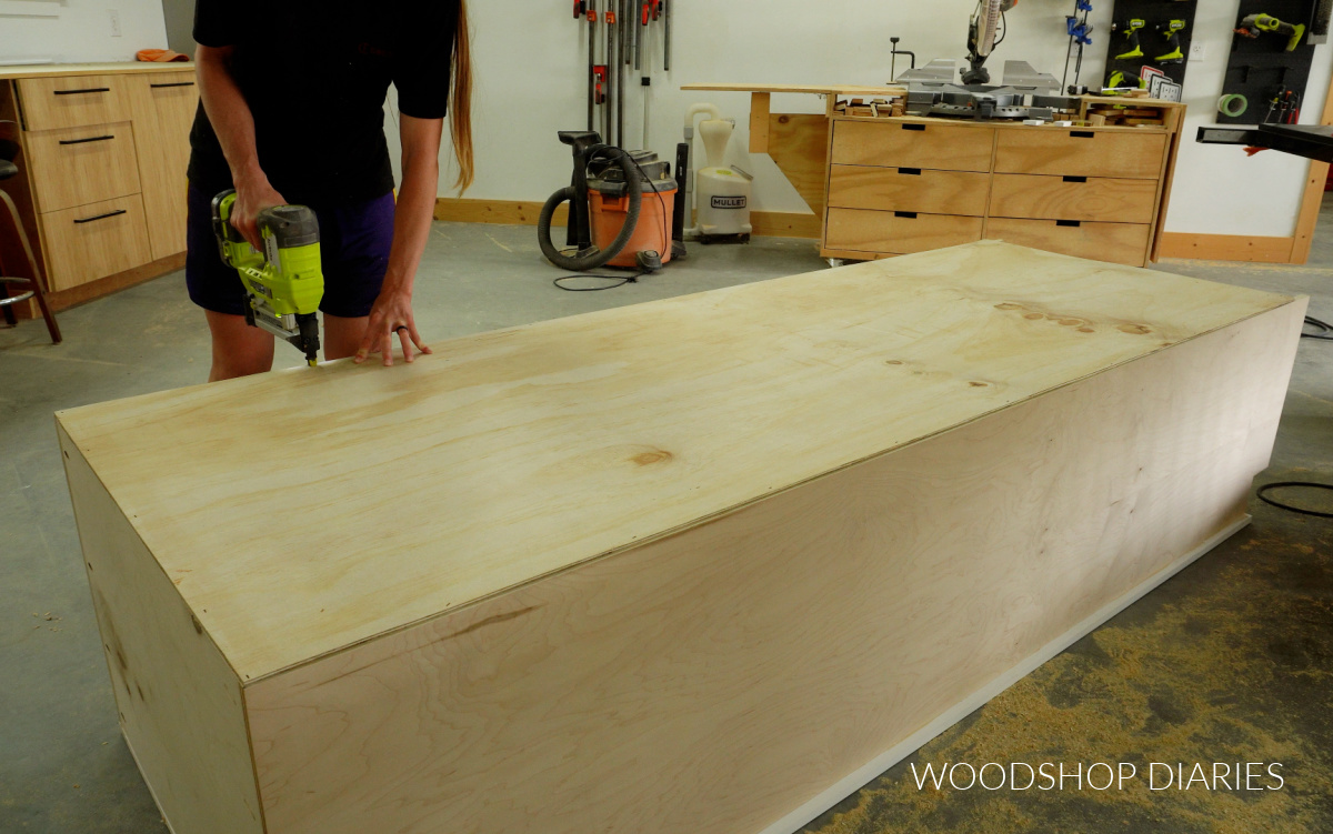 Shara Woodshop Diaries stapling back panel onto pantry cabinet