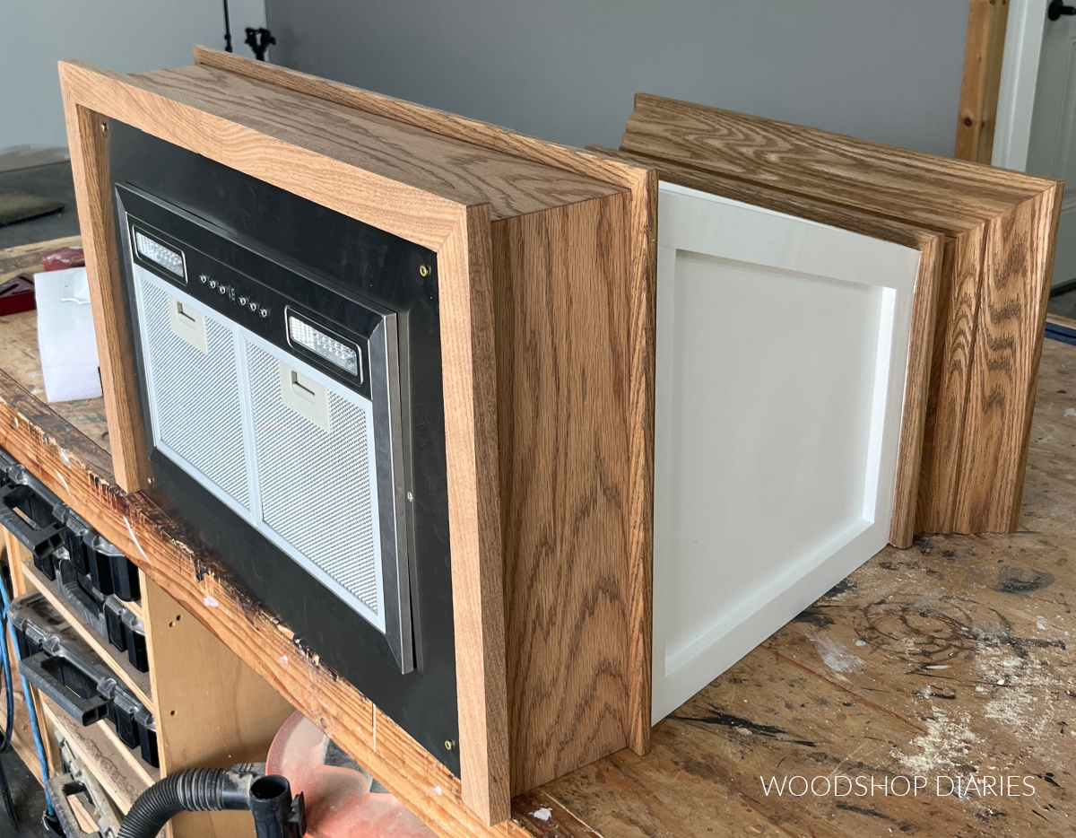 fan insert test fit into range hood cover on workbench