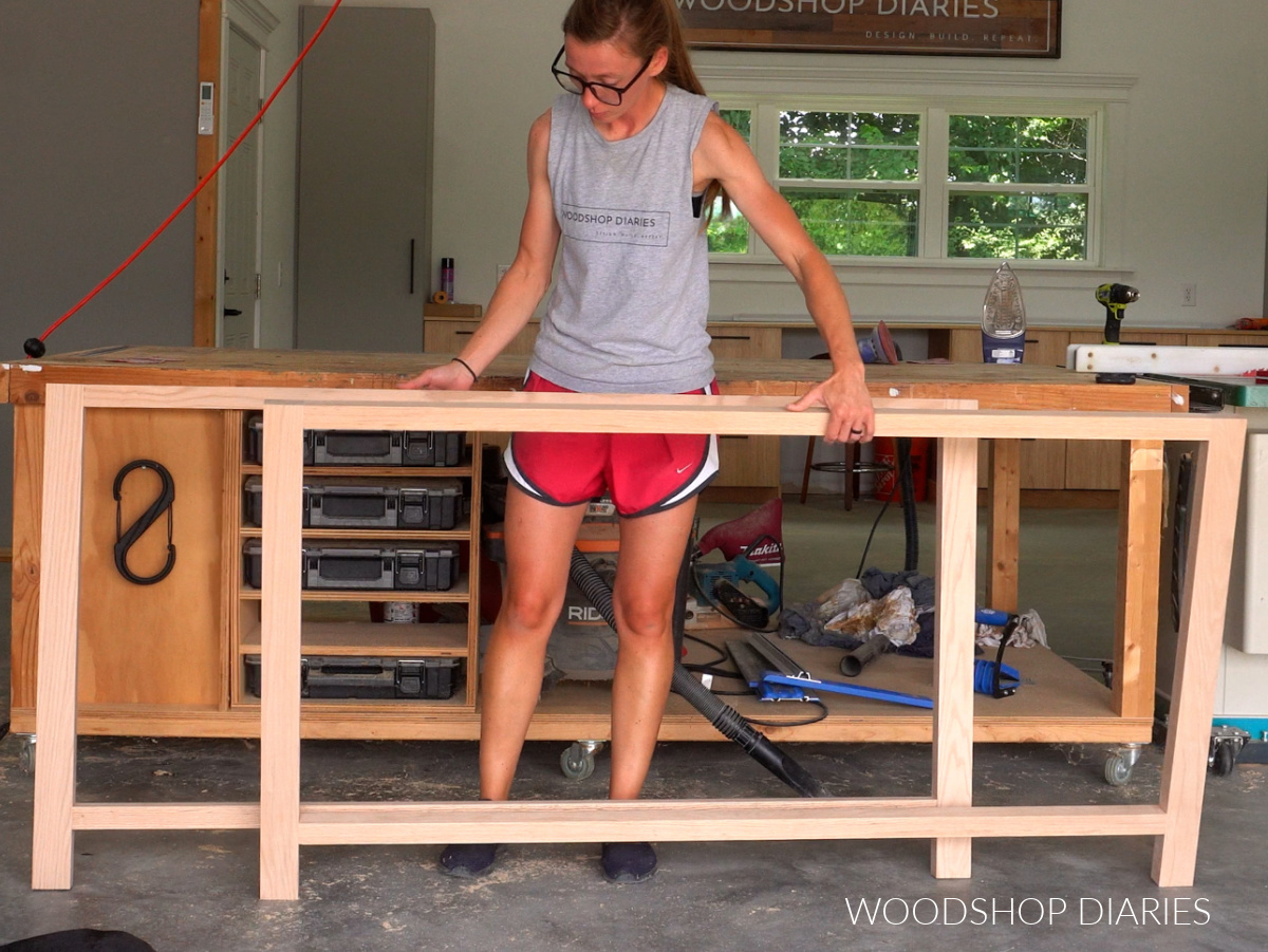 Shara holding front and back dresser frames in workshop