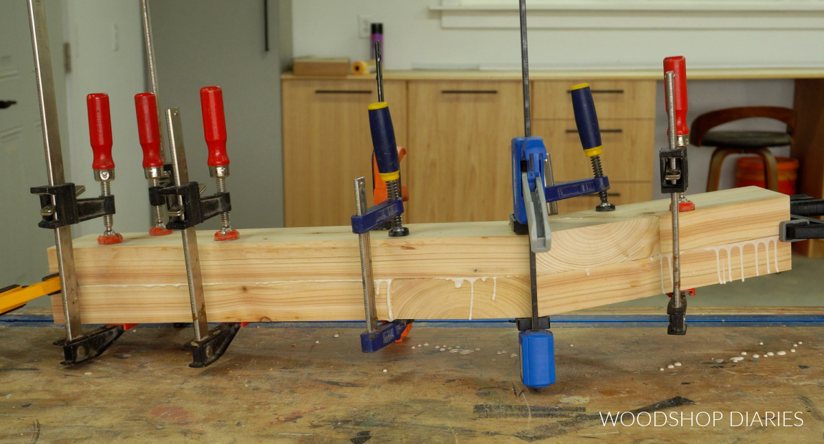 Gluing up 2x4 posts on workbench with clamps