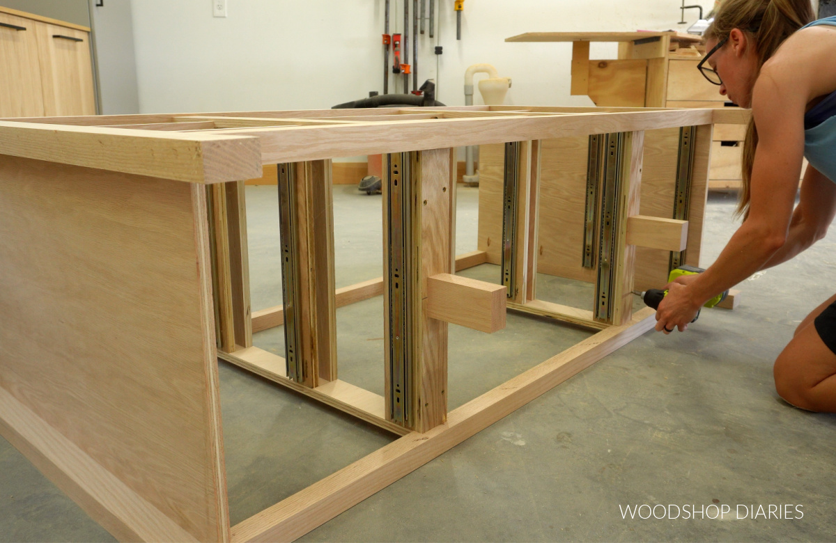 Shara Woodshop Diaries installing middle supports into dividers of 9 drawer dresser frame
