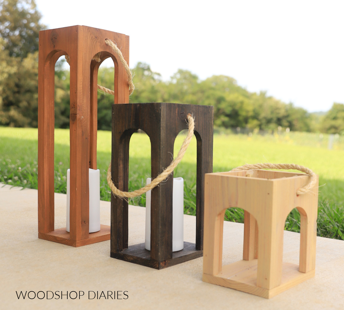 set of three wooden arched lanterns in different colors on porch