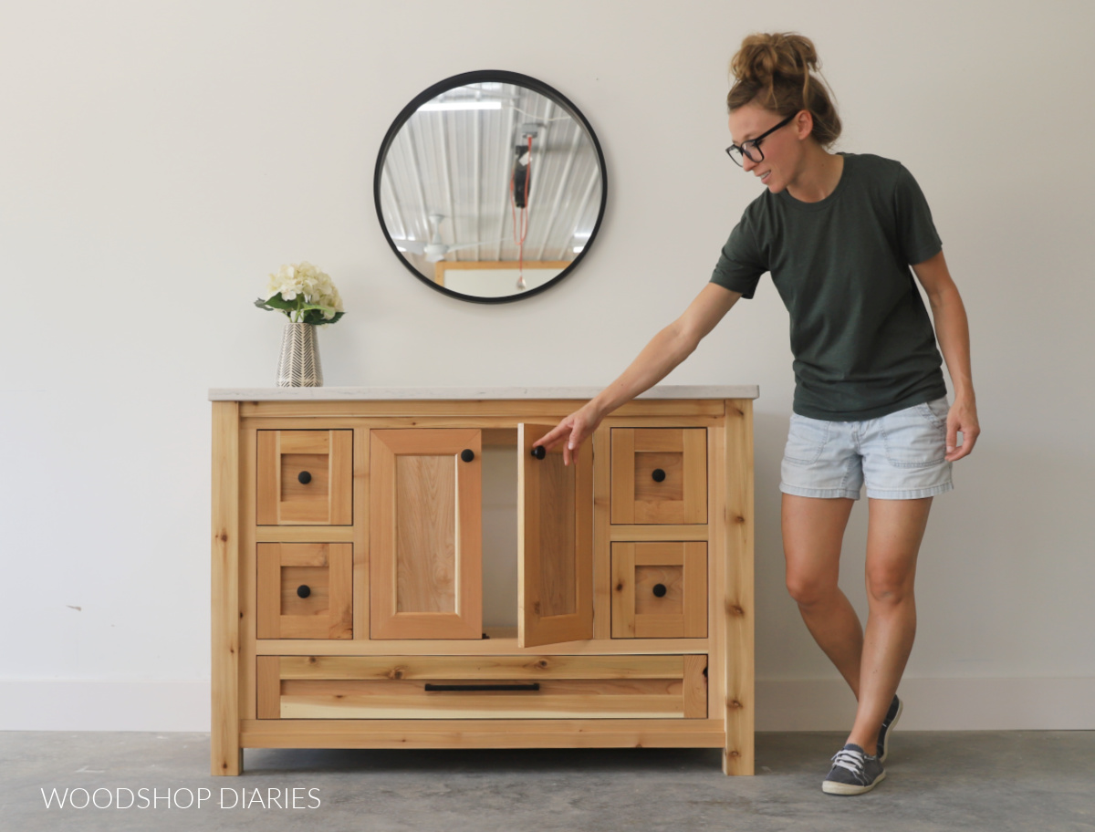 Shara Woodshop Diaries opening cabinet door of DIY single sink bathroom vanity 
