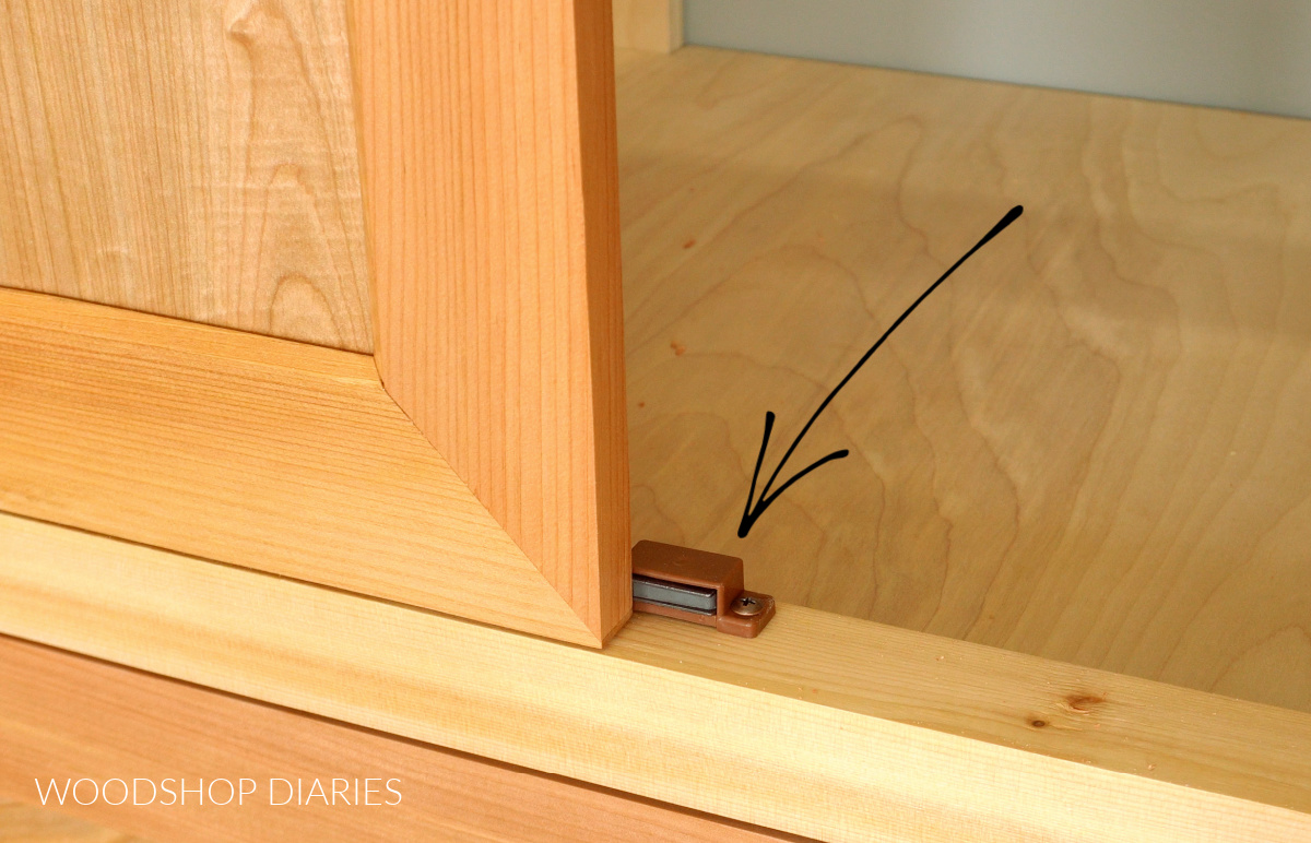Magnetic catch as stop block behind cabinet door