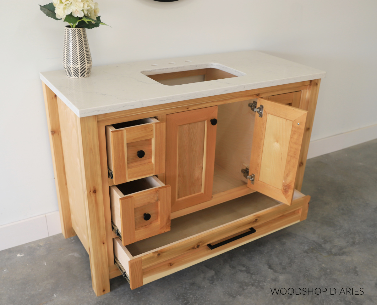 Bathroom vanity cabinet with drawers and doors open with view of countertop set in place