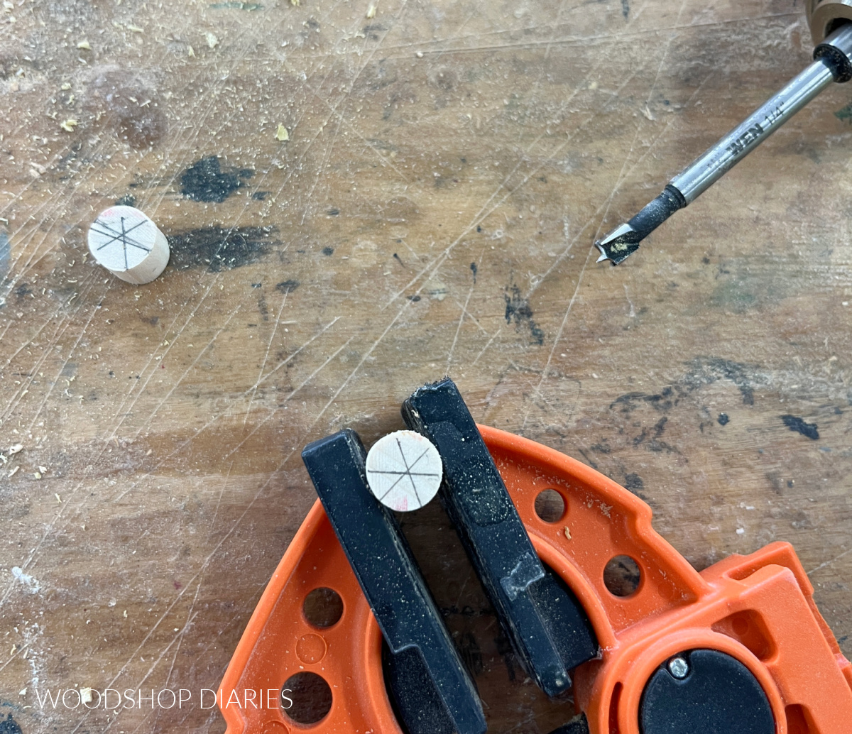 ½" dowel clamped with ¼" forstner bit laying next to it