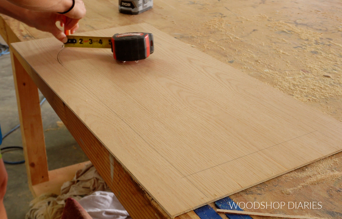 Drawing arc on plywood door using tape measure rotating around screw