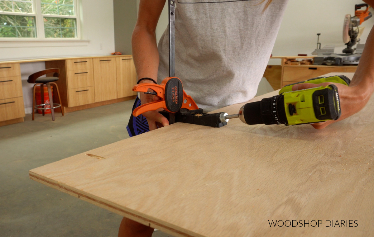 Close up of Shara Woodshop Diaries drilling pocket hole with Kreg Micro Pocket Hole Jig on plywood panel