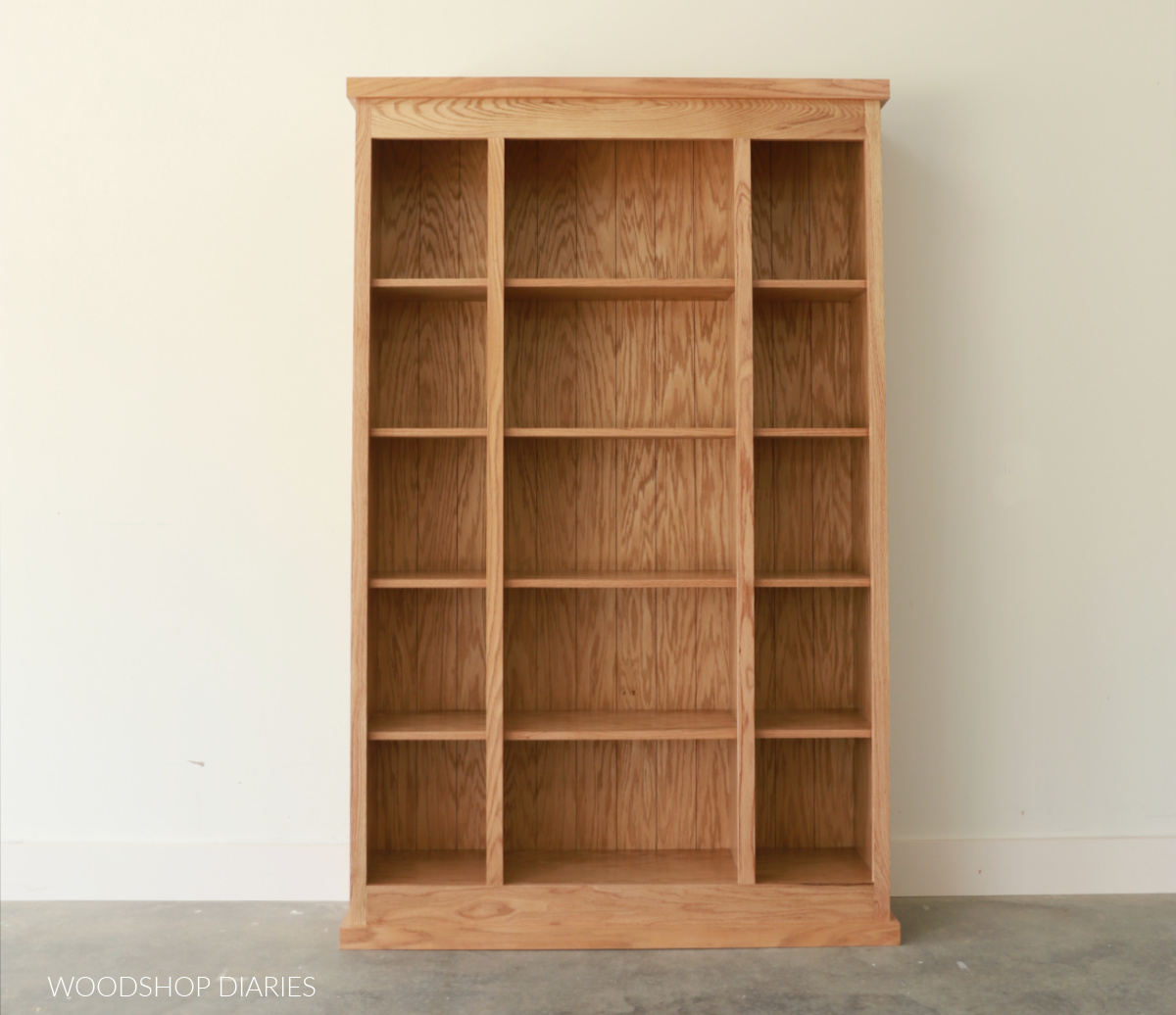 Empty finished red oak bookcase with three sections and five shelves in each