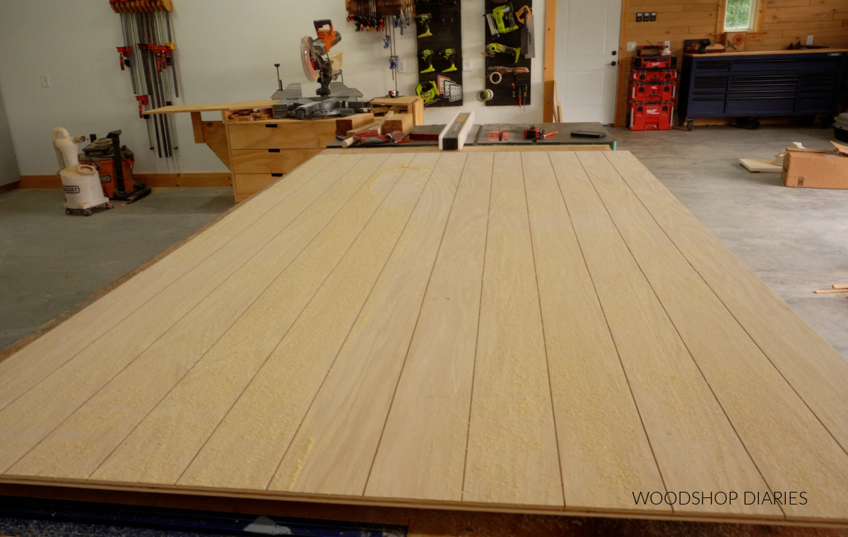 ½" plywood panel on workbench with dadoes cut on 4" intervals for faux shiplap back panel