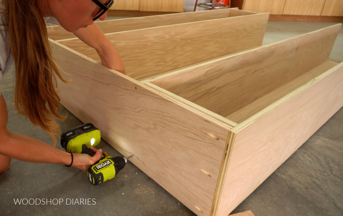 Shara Woodshop Diaries securing bookcase dividers to top panel with screws