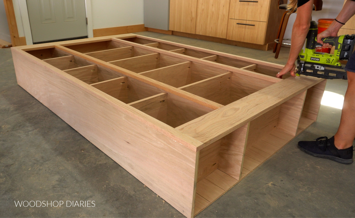 Shara Woodshop Diaries nailing face frame onto front of bookshelf with finish nailer