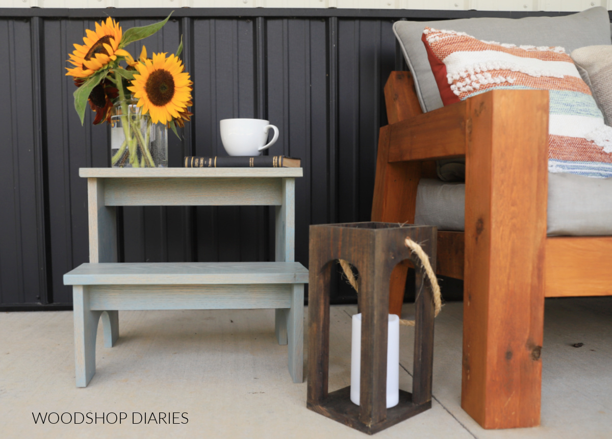 front view of DIY side table with two tiers next to outdoor loveseat