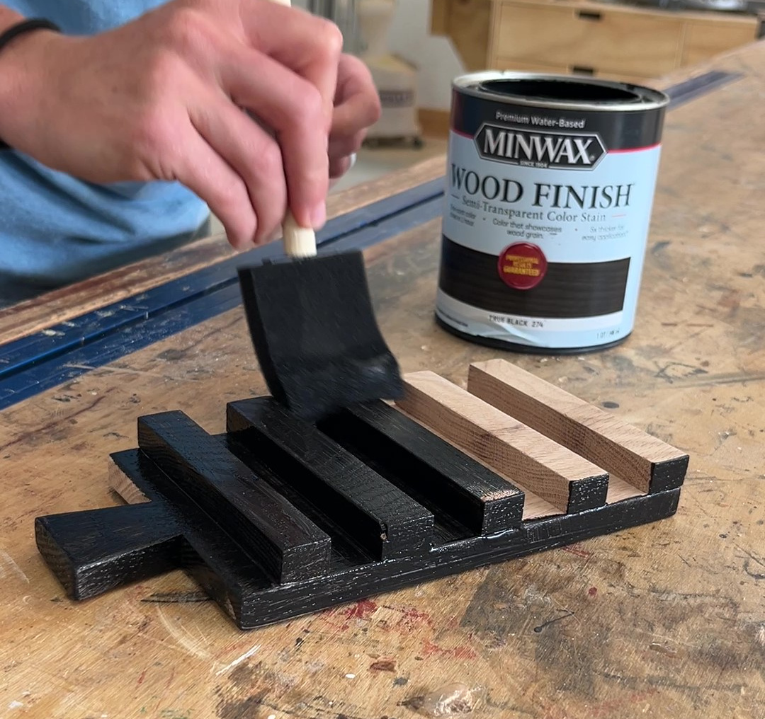 applying black stain to drink coaster tray