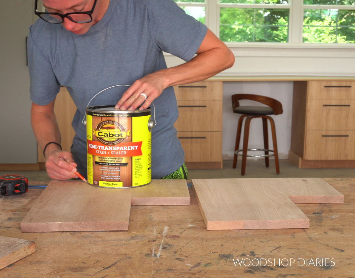 Shara Woodshop Diaries tracing around stain can on side panels of plant stand on workbench