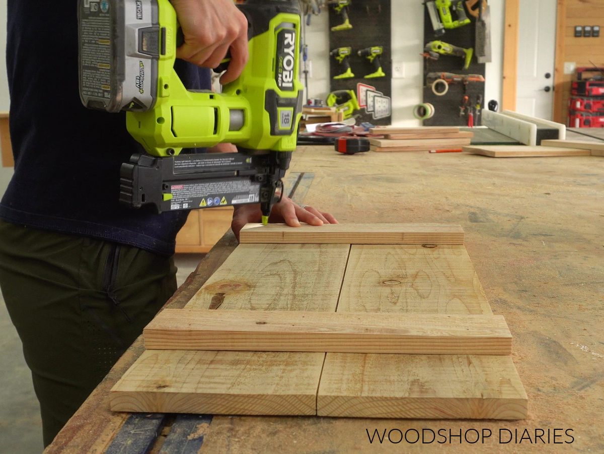 Shara Woodshop Diaries nailing bottom of wheelbarrow together with brad nailer