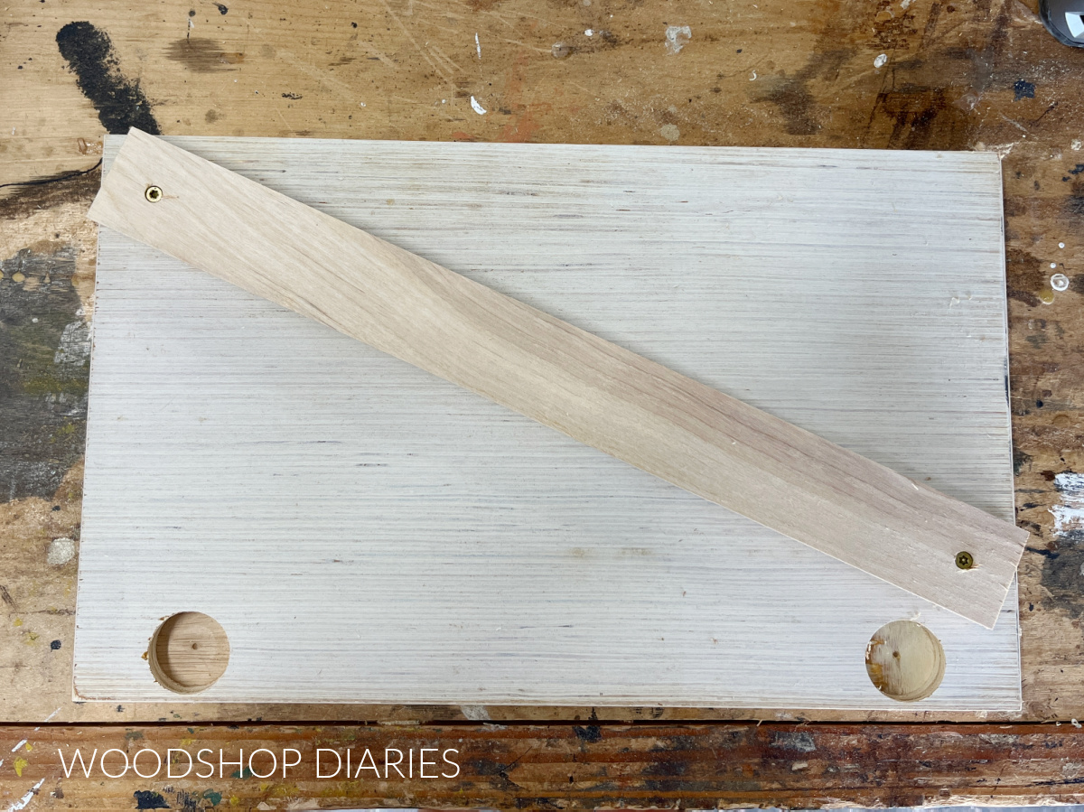 Overhead view of cabinet door with 1x2 cleat screwed across diagonal