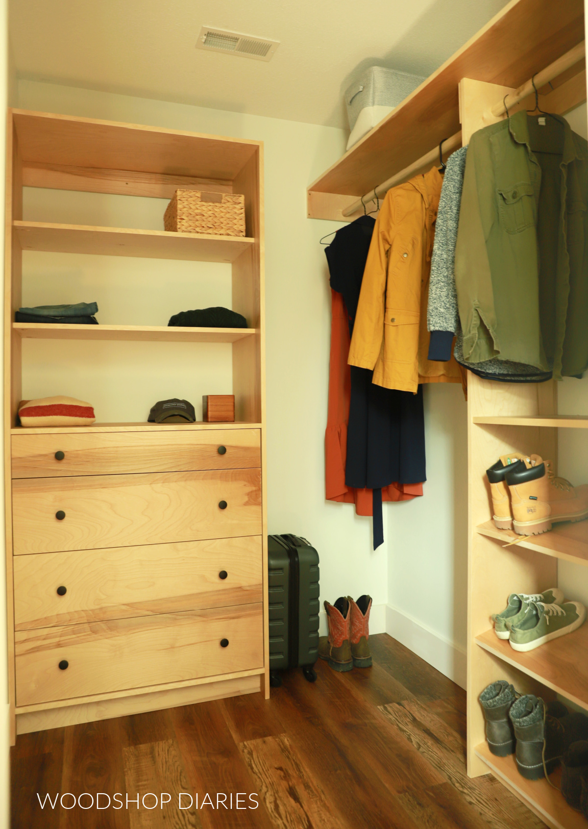 Small walk in closet with custom plywood cabinets with shelves and drawers and hanging rods