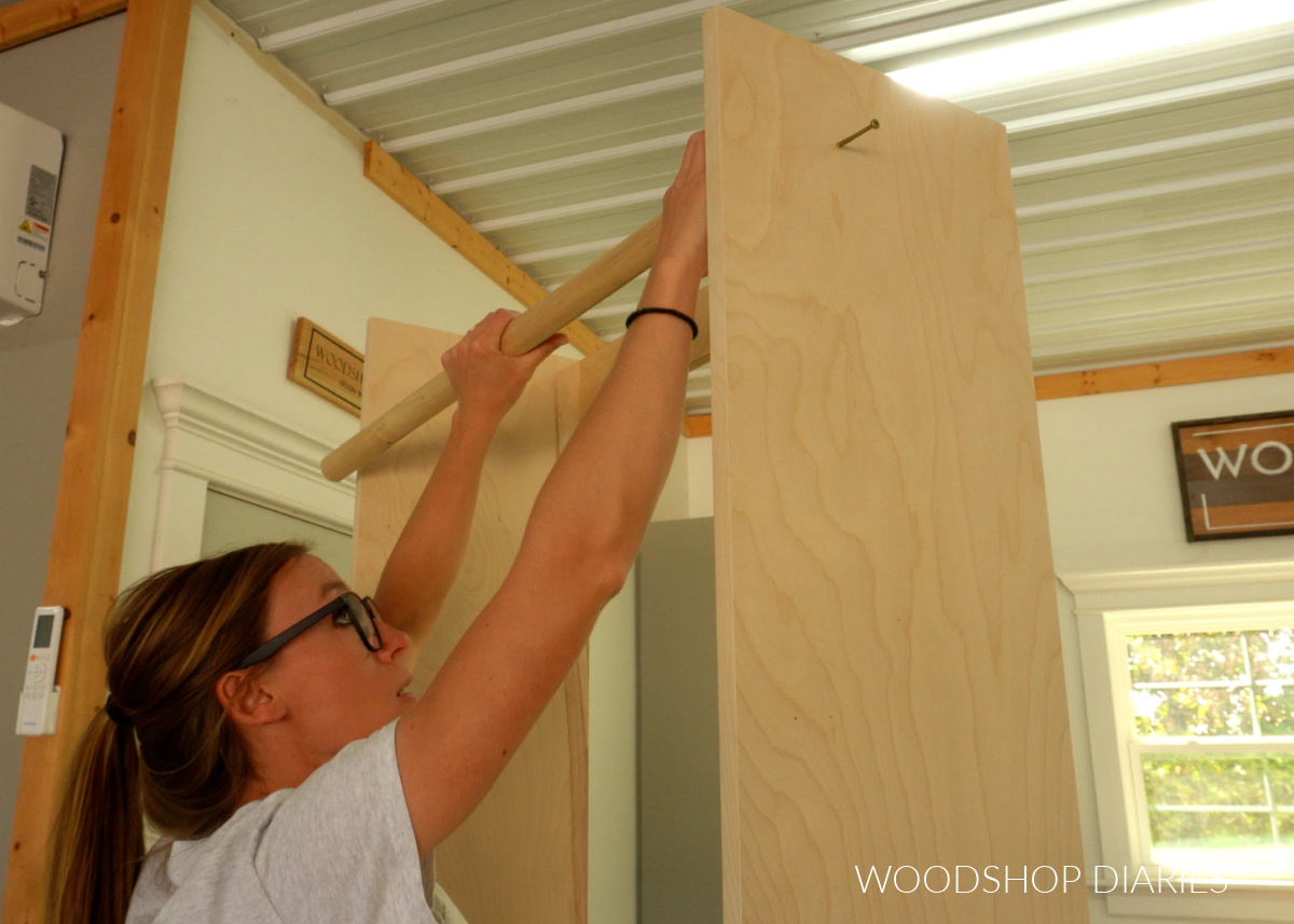 Shara Woodshop Diaries test fitting hanging rod between side panels of closet cabinet
