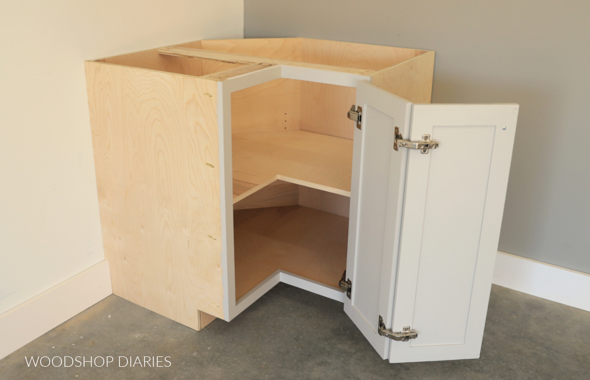 Bi fold corner base cabinet with adjustable shelf inside and doors open