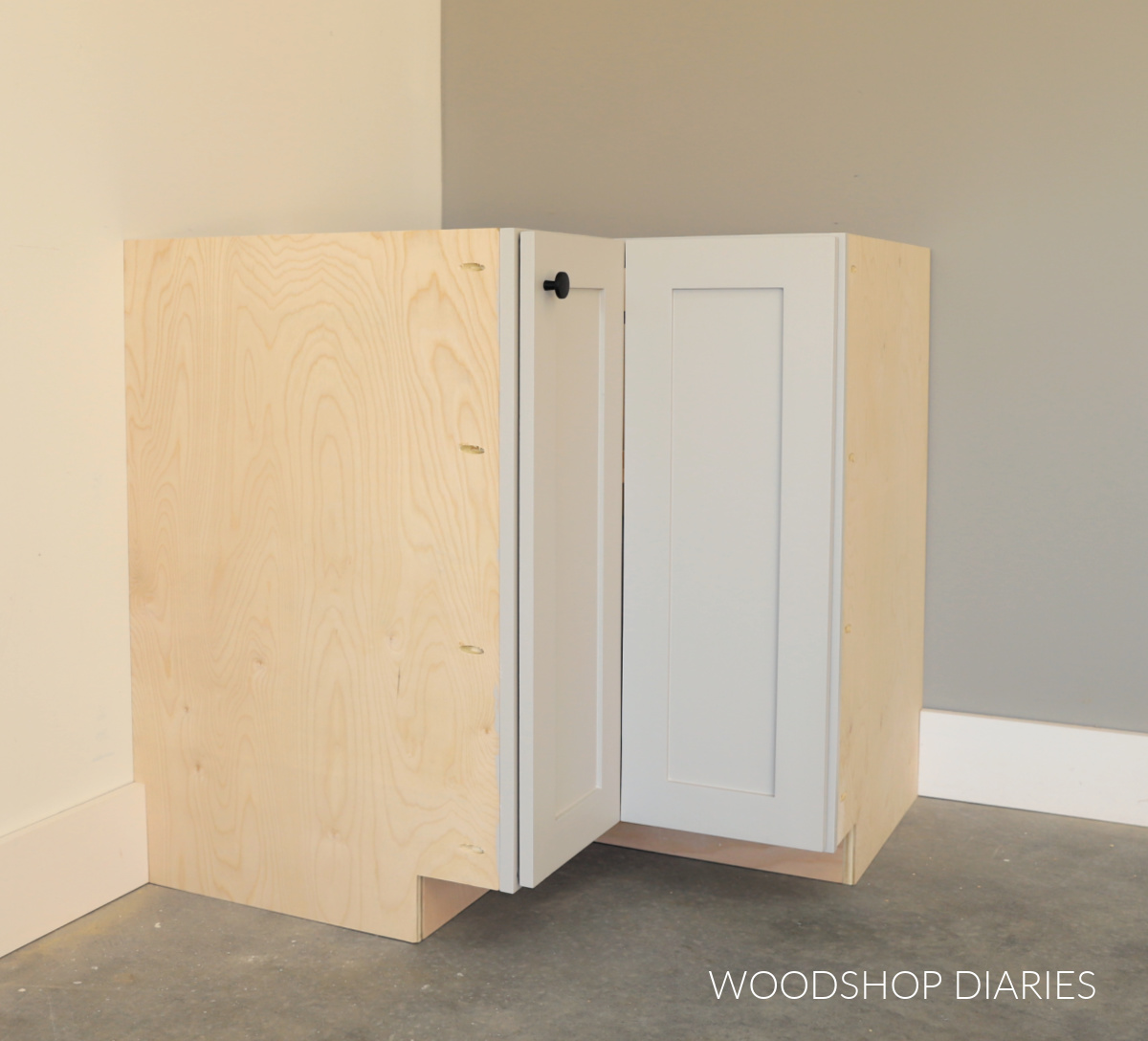DIY corner base cabinet with bi-fold doors sitting in corner of room--no cabinets on the sides