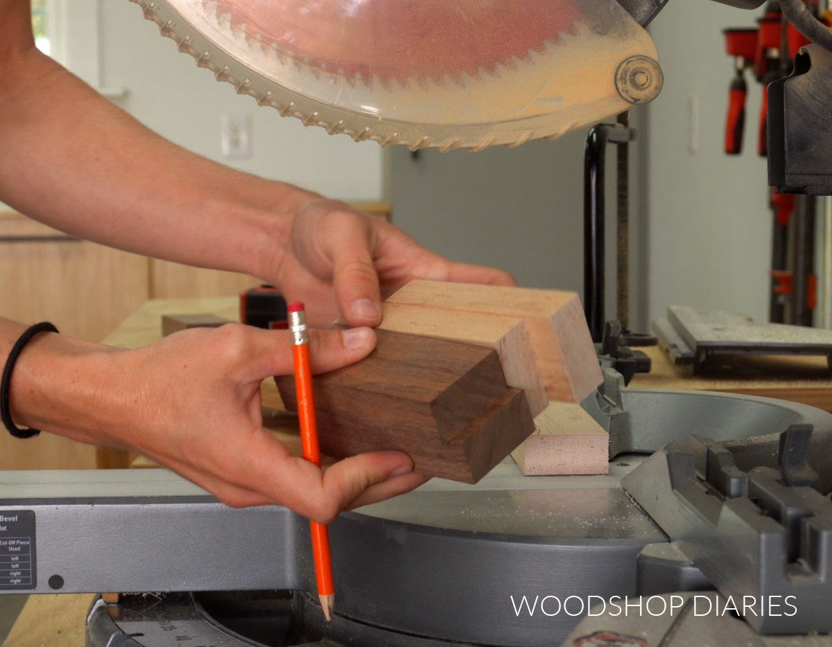 Shara Woodshop Diaries holding1x2 walnut and maple pieces cut to 4" long in front of miter saw