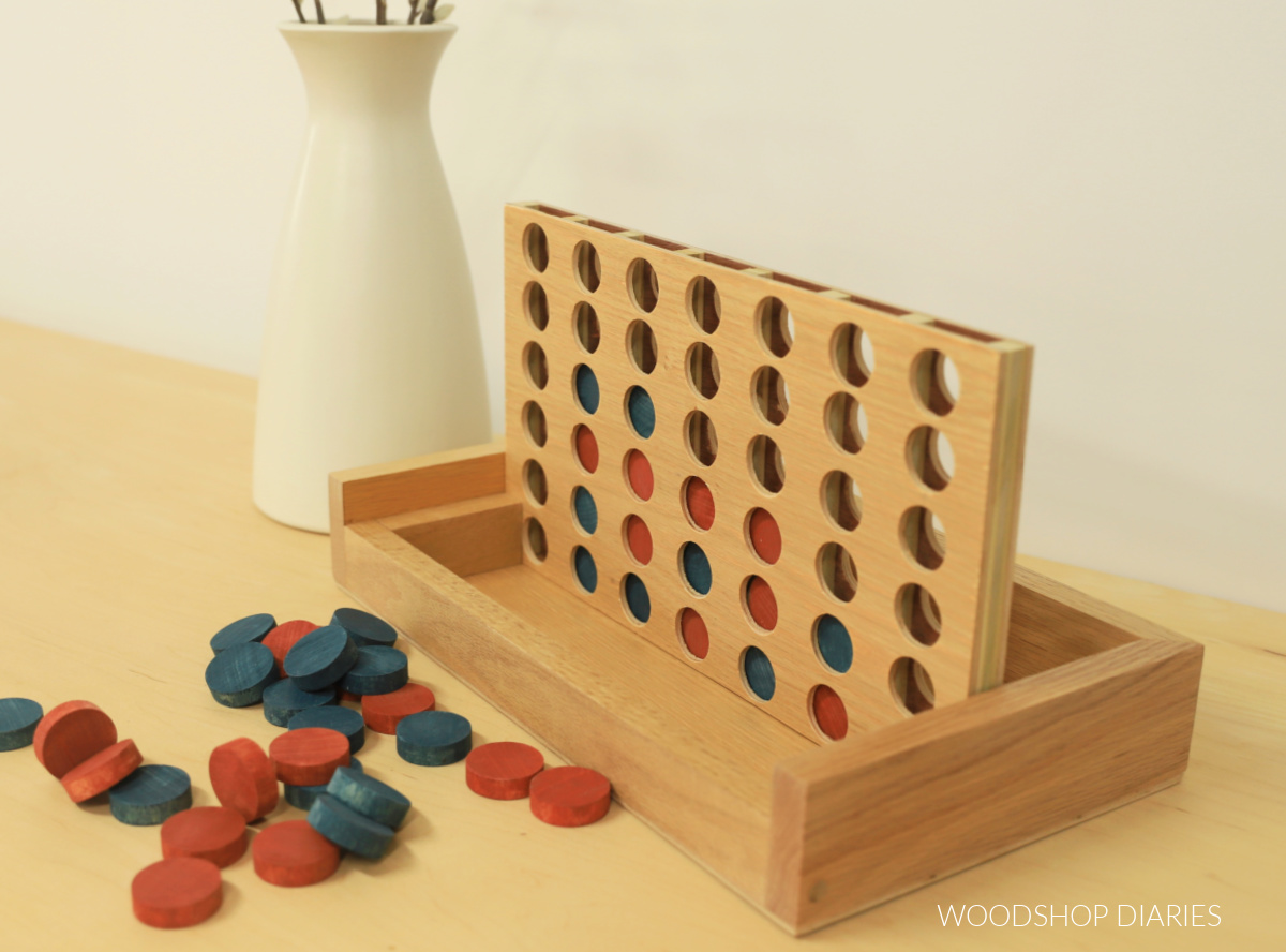 Completed wooden 4 in a row game board in storage box/stand with blue and red game board pieces