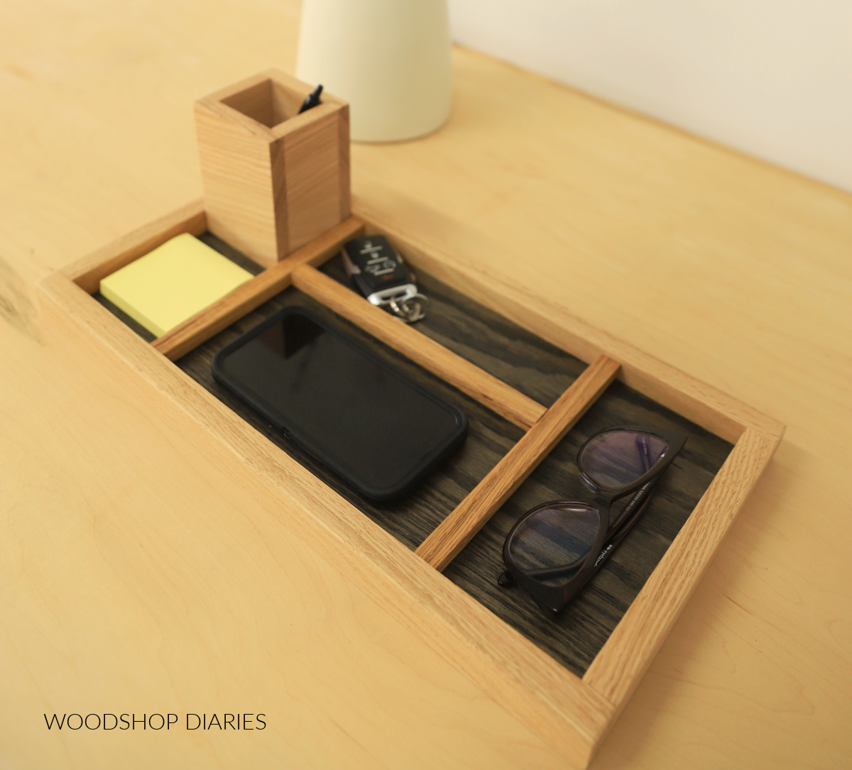 Red oak DIY desk organizer tray with post it notes, glasses, phone, pens, and keys