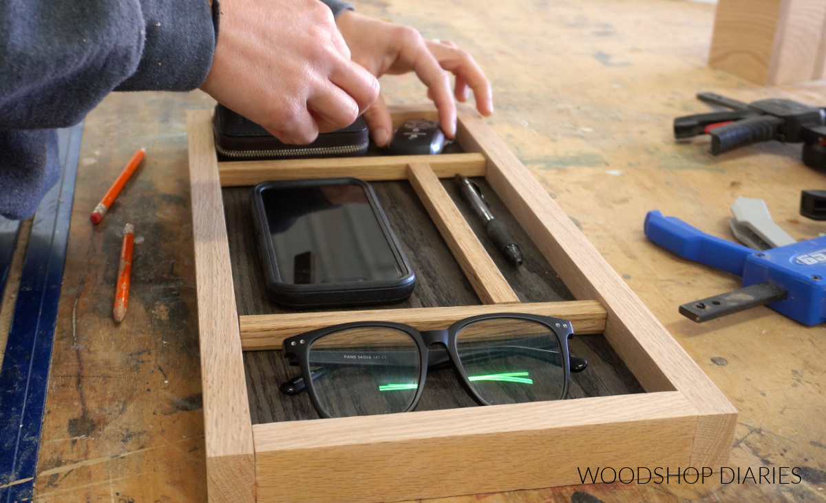 Shara Woodshop Diaries arranging items in catch all tray to test layout of dividers
