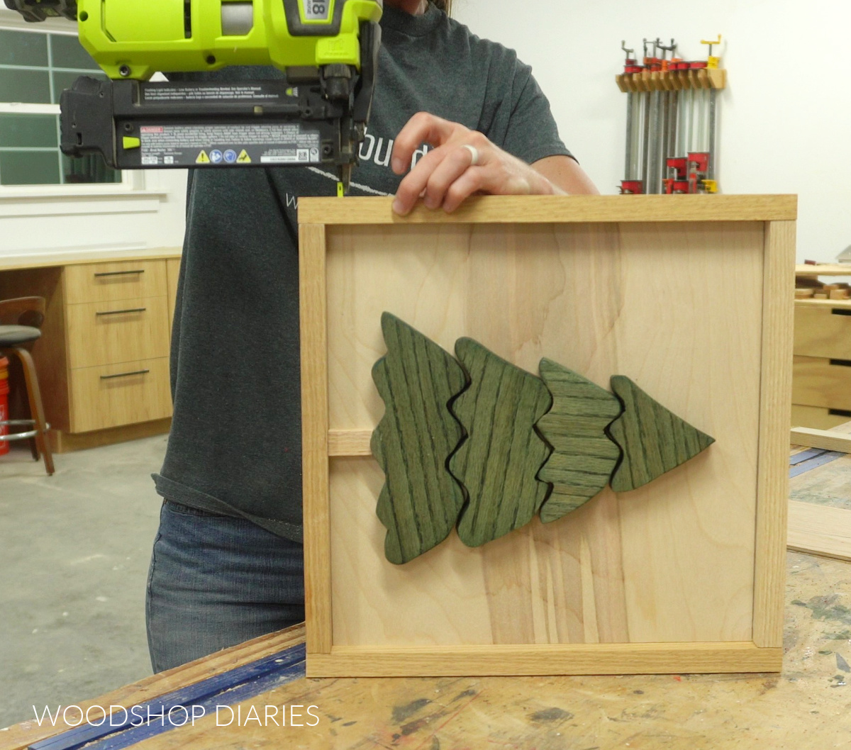 Shara Woodshop Diaries nailing 1x2 frame around Christmas tree wood art piece