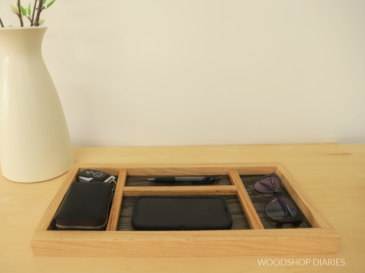 DIY catch all tray with glasses, phone, pens, keys, wallet on wood countertop