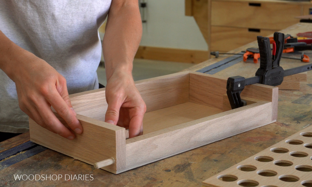 Shara Woodshop Diaries placing game board supports into storage box for 4 in a row game