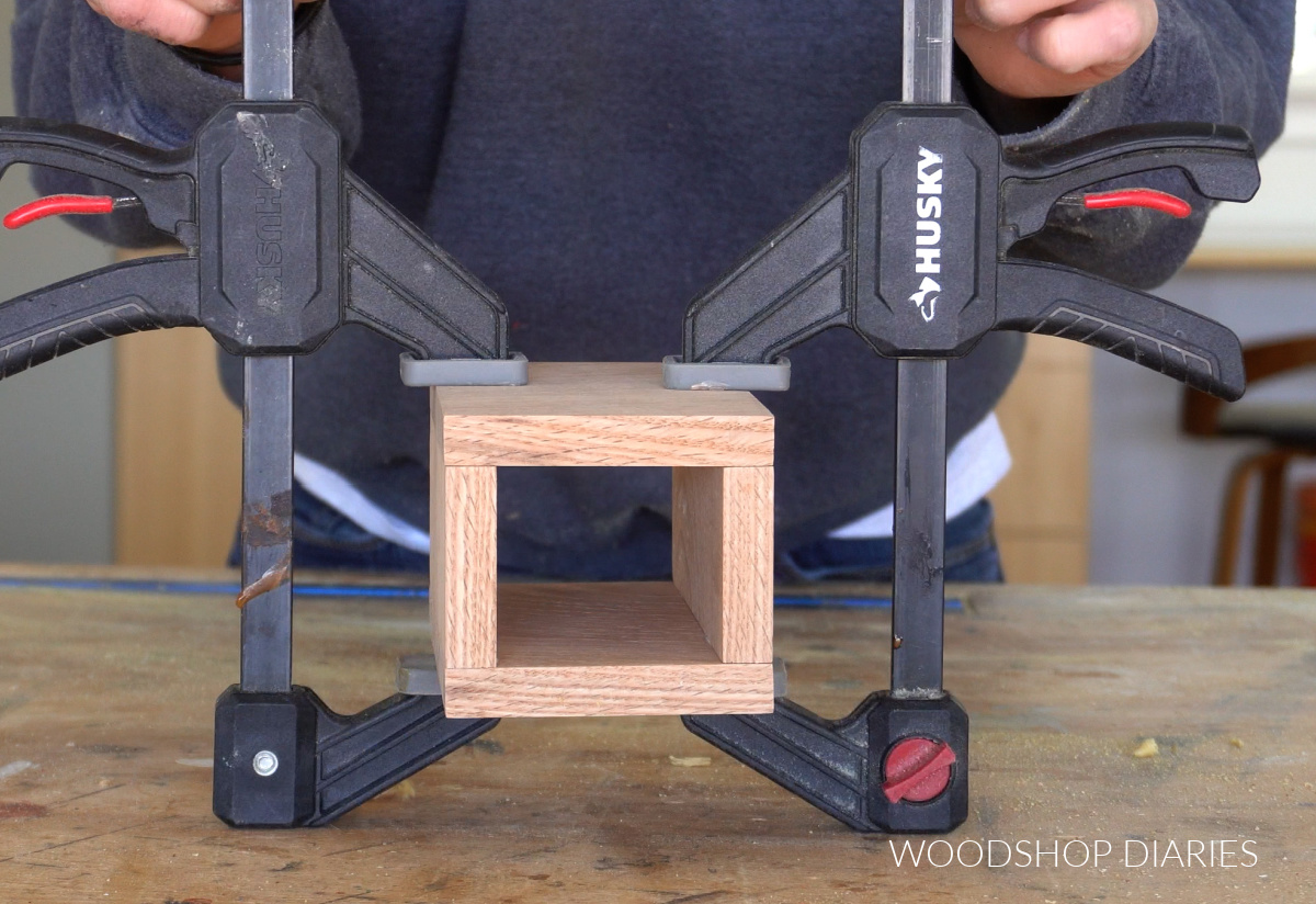 four pieces of pencil holder glued together in clamps on workbench for DIY catch all tray