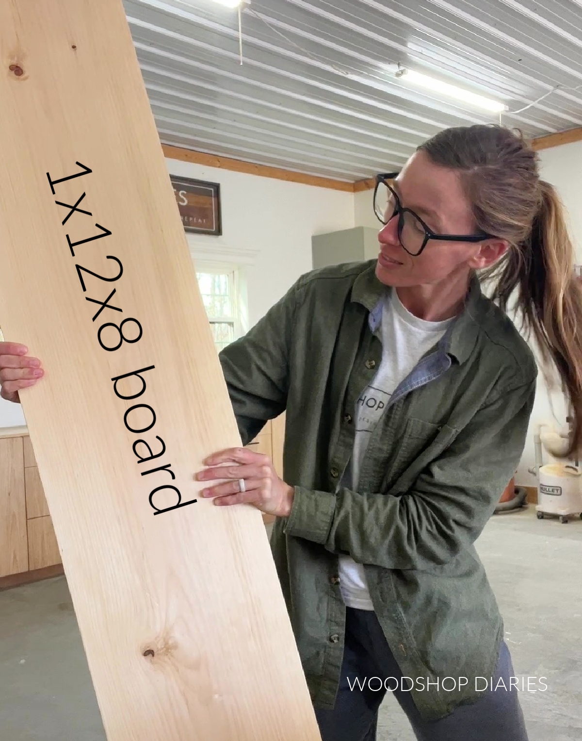 Shara Woodshop Diaries holding 1x12x8 board in workshop